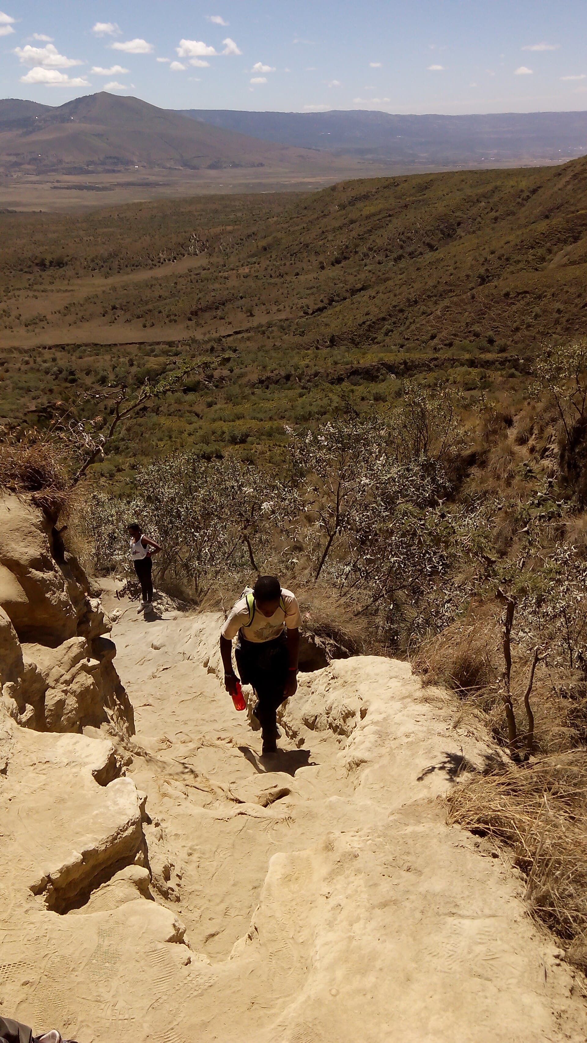 Hikers climbing the steep dusty trail on Mount Longonot